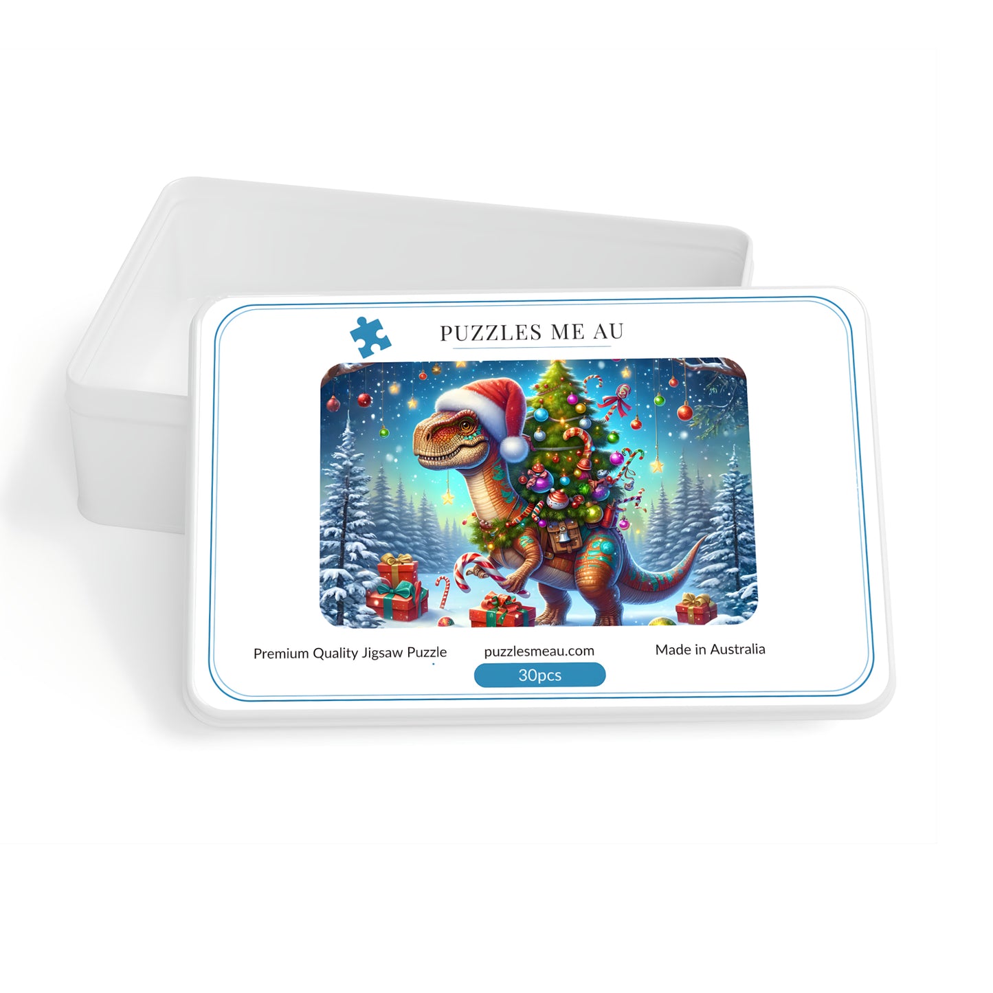 A rectangular jigsaw puzzle tin on a white background, with the lid leaning behind the front. The front shows a colorful illustration of a dinosaur wearing a Santa hat and carrying a Christmas tree in a snowy night scene.